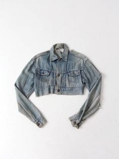 "This is a vintage 1950s denim jacket with customization. The soft, light wash denim jacket has beige single stitching throughout, 2 front pockets and snap front closure.Rips and tears add great style. The denim jacket was found customized with this great cropped cut. A great layering piece!  -  custom crop denim jacket -  light wash denim -  soft, thin denim - 2 front pockets with snap front closure    CONDITION In good condition consistent with wear and age. The soft denim is thin and has general fraying though-out jacket.  The denim has ripped detailing on back neck area giving the jacket great character. Approximate Fit:  Medium MEASUREMENTS Bust: 38\"  ...  96.5 cm Length: 13.5\" ...  34.3 cm Waist: 34\" ...  86.4 cm Shoulders: 19\"  ...  48.3 cm Neck to Sleeves End: 34.5\" ... 87.6 c Denim Jacket Grunge, Buckskin Dress, 90s Denim Jacket, Mod Jacket, Crop Denim Jacket, Hipster Jeans, Light Wash Denim Jacket, Wool Sweater Men, Fitted Denim Jacket