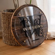 a wooden sign that says wilson's on it next to a basket with a plant in it