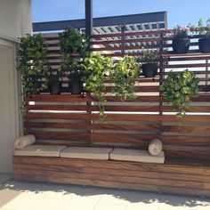 a wooden bench with potted plants on it