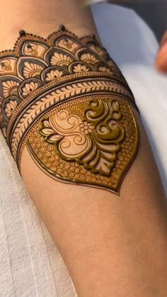 a woman's arm with a henna tattoo on it