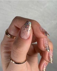 a woman's hand with pink and gold nail polish