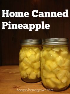 two jars filled with pineapples sitting on top of a wooden table