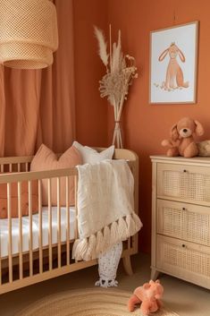 a baby's room with an orange wall and white crib