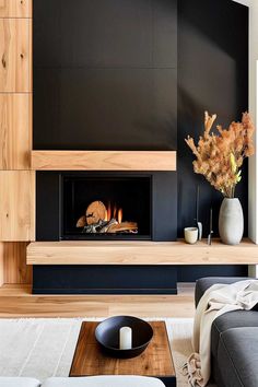 Modern black fireplace with rustic wooden touches in inviting living room. Modern Black Fireplace, Midcentury Modern Fireplace, John Maclean, Fireplace Wall Ideas, Scandinavian Fireplace, Mid Century Modern Fireplace, Fireplace Walls, Modern Wood Burning Stoves