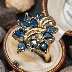 This impressive cocktail ring is accented with ten (10), prong set, pear mixed cut natural blue sapphires and five (5), prong set, round brilliant cut diamonds. The ring measures 23.9mm at the top, rises 10.6mm above the finger, tapering to 3.0mm wide and 0.8mm thick at the base of the shank. This ring is currently a size 9.5. Antique Cocktail Ring, Antique Jewellery Designs, Gold Cocktail Ring, Blue Sapphire Diamond, Fabulous Jewelry, Pretty Rings, Emerald Jewelry, Natural Blue Sapphire, Jewellery Designs