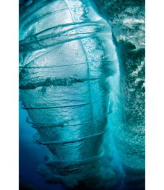 an underwater view of the bottom part of a boat in blue water, looking up at it's hull