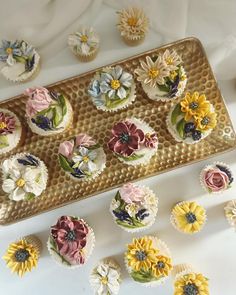 cupcakes decorated with flowers are on a tray