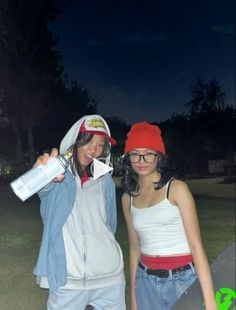 two young women standing next to each other in the grass with one holding a water bottle