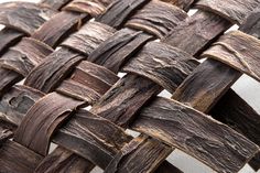 a close up view of the woven material on a wooden bench seat, which is made out of wood planks