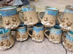 a group of coffee cups sitting on top of each other in front of a pile of rocks