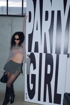 a woman posing in front of a party girl sign