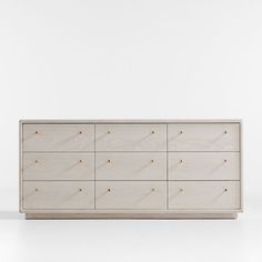 a white dresser with gold knobs on the top and bottom drawers, against a white background