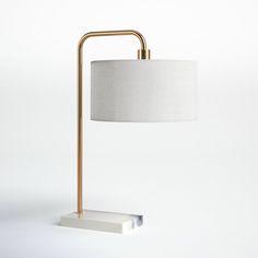 a lamp that is on top of a white surface with a light shade over it