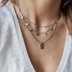 This layered necklace, made from stainless steel, consists of two different lengths of chain which connect together and close at the center back with a lobster claw clasp. The shorter chain is unadorned and sits higher on the chest than the longer chain, which has nine small circular pendants with a textured surface hanging from it. There is also a short length of chain at the back which is made from larger links and which has a small seashell charm attached to the end, making the overall fit of the necklace adjustable. Length: 41.0 cm (16.14 inches) simple chain, 42.0 cm (16.53 inches) chain with circles Length Extension: 5.5 cm (2.16 inches) Pendant Size: 0.5 cm (0.19 inches) Weight: 7.0 g (0.24 oz) Also available in rose gold and gold: Textured Circle Layered Necklace Rose Gold https:// Minimalist Double Chain Metal Charm Necklaces, Minimalist Double Chain Metal Charm Necklace, Minimalist Metal Charm Necklace With Double Chain, Minimalist Multi-strand Metal Layered Necklace, Layered Metal Chain Necklace For Gift, Dainty Silver Multi-strand Chain Necklace, Silver Multi-strand Dainty Layered Necklace, Silver Dainty Multi-strand Layered Necklace, Dainty Silver Multi-strand Layered Necklace