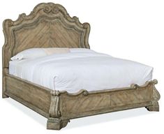 an antique style bed with white sheets and pillows