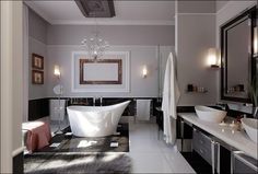 a bathroom with two sinks and a bathtub in the middle, along with a chandelier