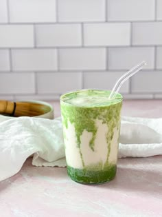 a green and white drink sitting on top of a table