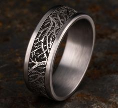 a wedding ring with an intricate design on the inside is shown in grey gold and silver