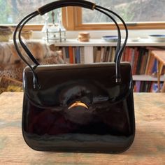 This Is A Beautiful Extremely Rare Vintage Small Handbag Made By The Coveted Judith Leiber In Black Patent Leather. Excellent Vintage Condition, No Rips, Tears, Scuffs, It Belonged To My Mother Who Only Used It Occasionally. Beautiful Half Moon Clasp And Gold Accents On The Handles, It Still Has The Small Mirror In The Pocket Inside. 3 Pockets, One Has Zip Closure. Small Bags Are The Latest Trend. 7" W X 5 1/2" H X 4"Deep Vintage Black Patent Leather Handbags, Classic Evening Bag With Top Handle For Formal Occasions, Designer Handheld Shoulder Bag For Formal Occasions, Classic Formal Evening Bag With Top Carry Handle, Formal Handheld Satchel With Dust Bag, Classic Black Rectangular Evening Bag, Classic Rectangular Evening Bag For Formal Events, Designer Evening Bag For Formal Occasions, Elegant Evening Box Bag With Dust Bag