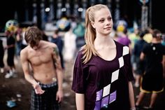 a young woman standing next to a man in front of a group of other people