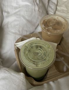 two plastic cups sitting on top of a wooden tray