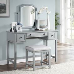 a bedroom with a vanity, stool and mirror in it's centerpieces