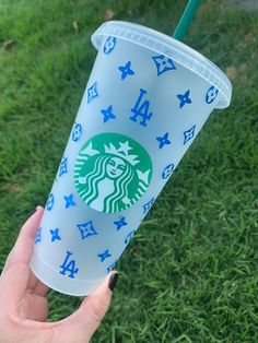 someone holding up a starbucks cup with blue stars and the number four on it in their left hand