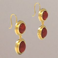 Bejeweled! These classic earrings add a touch of glamor to any occasion. Our Agrippina earrings feature a round garnet cabochon stone beneath which dangles a similar stone of oval shape; both are set into a beautifully articulated bezel. The earrings feature a Roman hook at the back, and are based on an ancient Roman example from the second century AD. Agrippina (or "little Agrippa") the younger (AD 13 - 59) was no other than the niece of the Roman emperor Claudius, and the mother of the emperor Classic Oval Cabochon Gemstone Earrings, Modern Oval Cabochon Earrings, Elegant Drop Earrings With Cabochon, Red Polished Fine Jewelry Earrings, Yellow Gold Gemstone Cabochons, Formal Dangle Earrings With Gemstone Accents, Elegant Red Earrings With Polished Finish, Red Round Earrings With Polished Finish, Formal Drop Cabochon Earrings