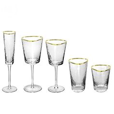 four wine glasses with gold rims are lined up