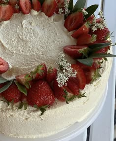 a white cake with strawberries and flowers on top