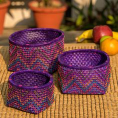 three purple baskets sitting on top of a mat