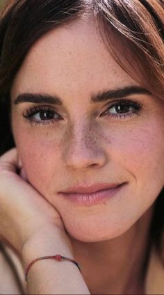 a close up of a person with a bracelet on their wrist and her hand near her face