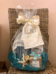 a gift basket that says beach house on the front, and is sitting on a wicker chair