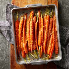 carrots in a baking pan on a wooden cutting board