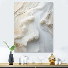 an abstract painting on the wall above a dresser with candles and vases next to it