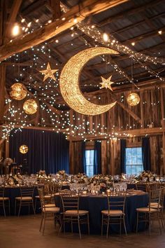 a large room filled with lots of tables covered in blue linens and stars hanging from the ceiling