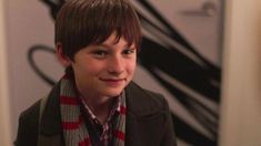 a young boy wearing a scarf and jacket