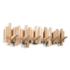 several pieces of wood are arranged in a row on a white surface, with one piece missing from the wall