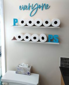 two shelves with toilet paper on them and one shelf above it that says everyone p is for