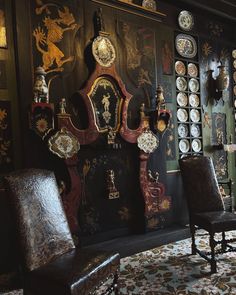 a room with many clocks on the wall and two chairs in front of one chair