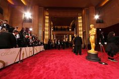 the oscars red carpet is lined up with people in tuxedos and onlookers