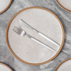 a plate with silverware on top of it next to other plates and utensils