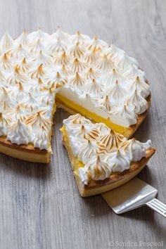 a pie with white frosting and a slice missing from it