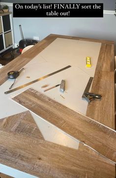 a table that has some scissors on it and is being sanded down with wood