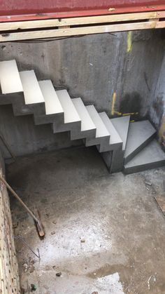 a set of stairs going up to the top of a building with concrete walls and flooring