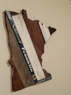 a piece of wood that has been cut into the shape of a state with hockey stickers on it