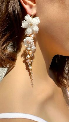 a woman wearing earrings with flowers on it