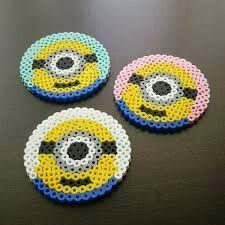 three minion beaded coasters sitting on top of a table