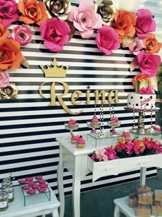 there is a table with flowers on it and cake in front of the sign that says reina