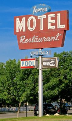 a sign for a motel that says, topper restaurant cocktails pool and hot dog